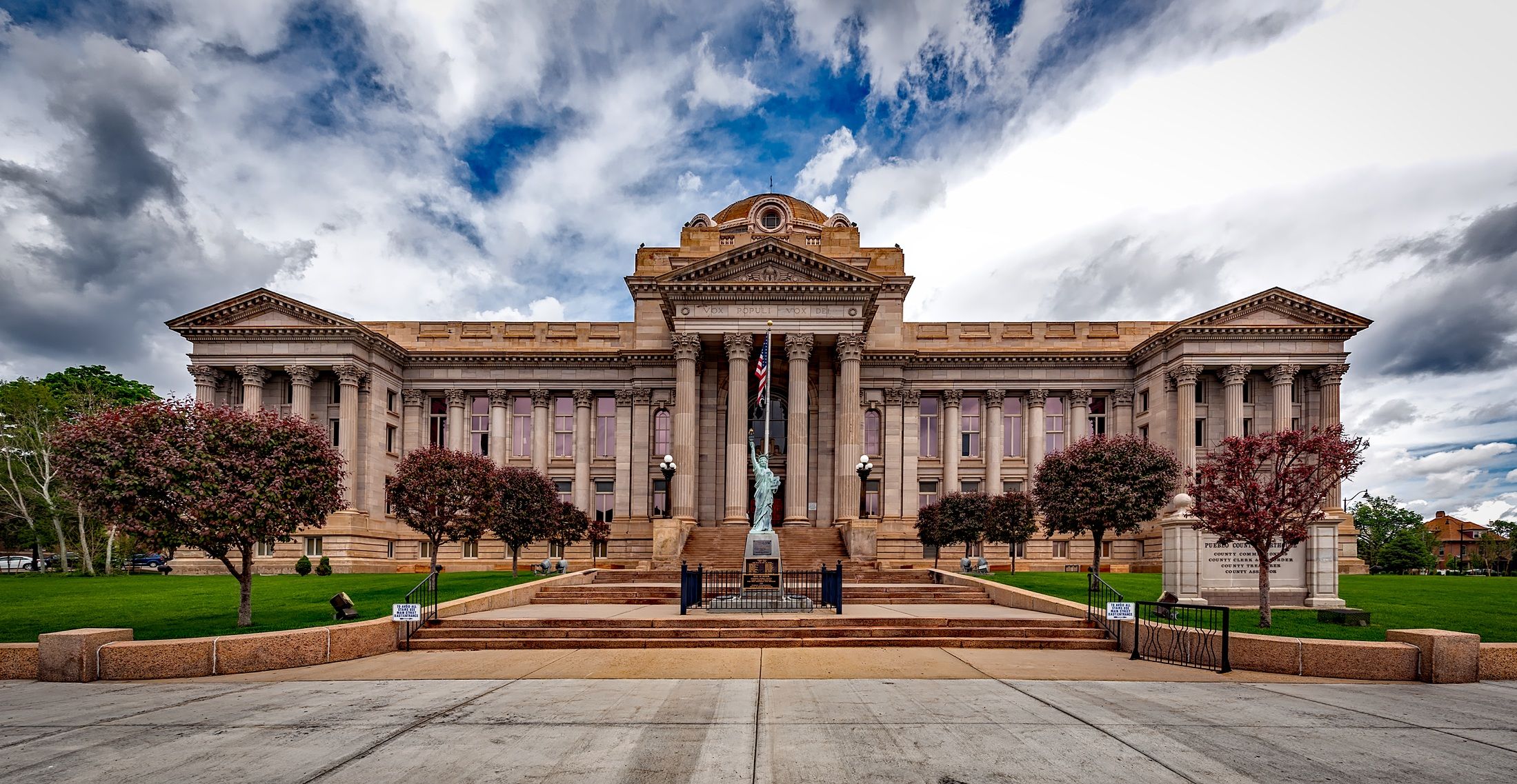 Neoclassical courthouse facade with greenery, symbolizing court proceedings that continue after a client switches lawyers