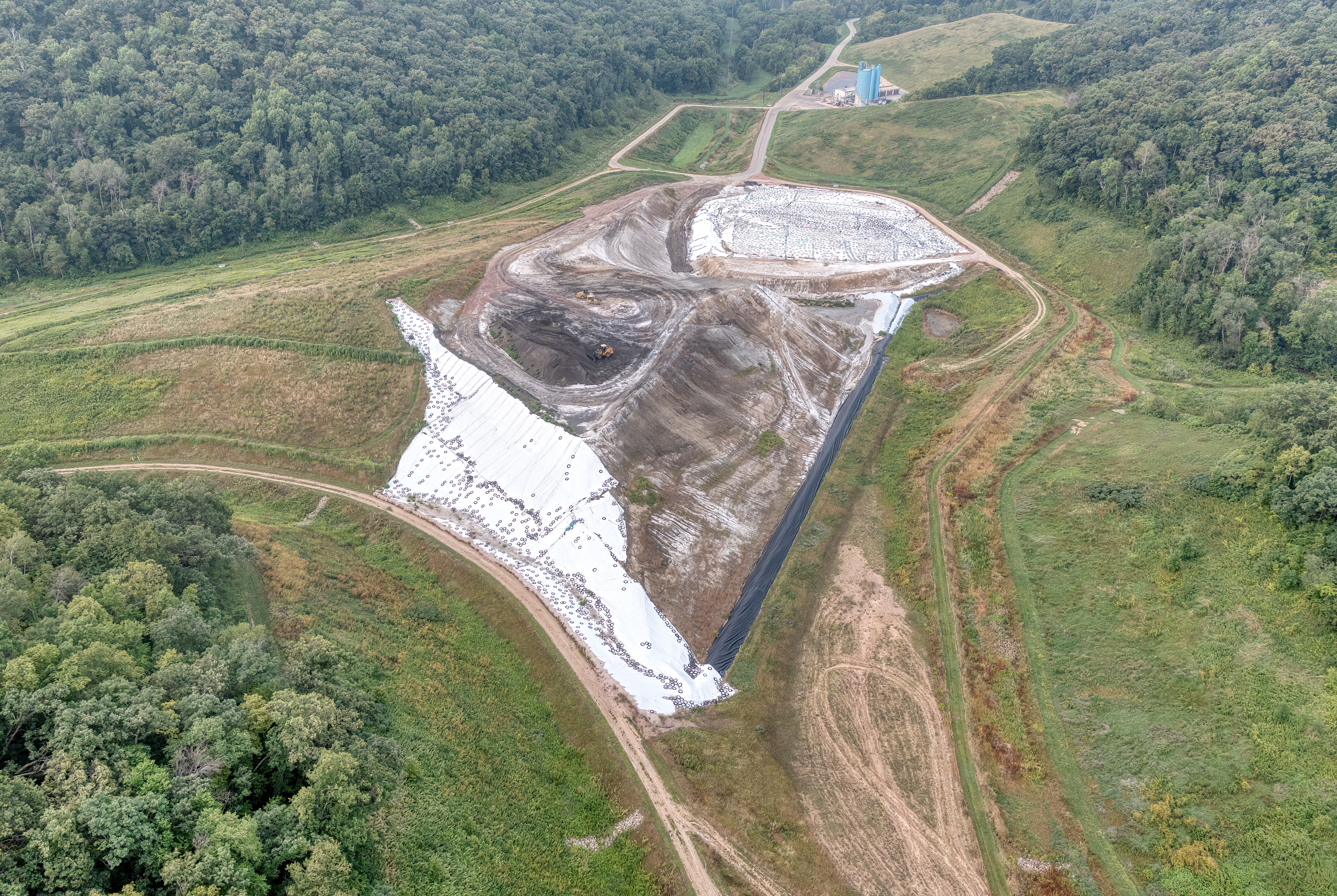 Aerial view of a construction site and surrounding landscape, illustrating permitting and impact assessment considerations.